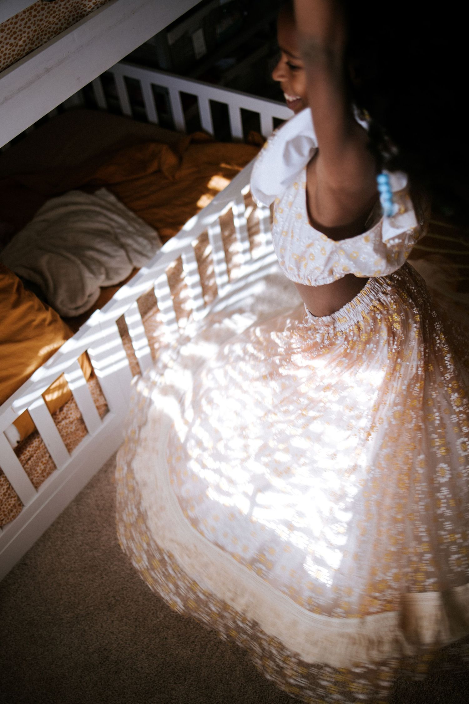 Sunlight creates geometric patterns on a flowing white lace dress.