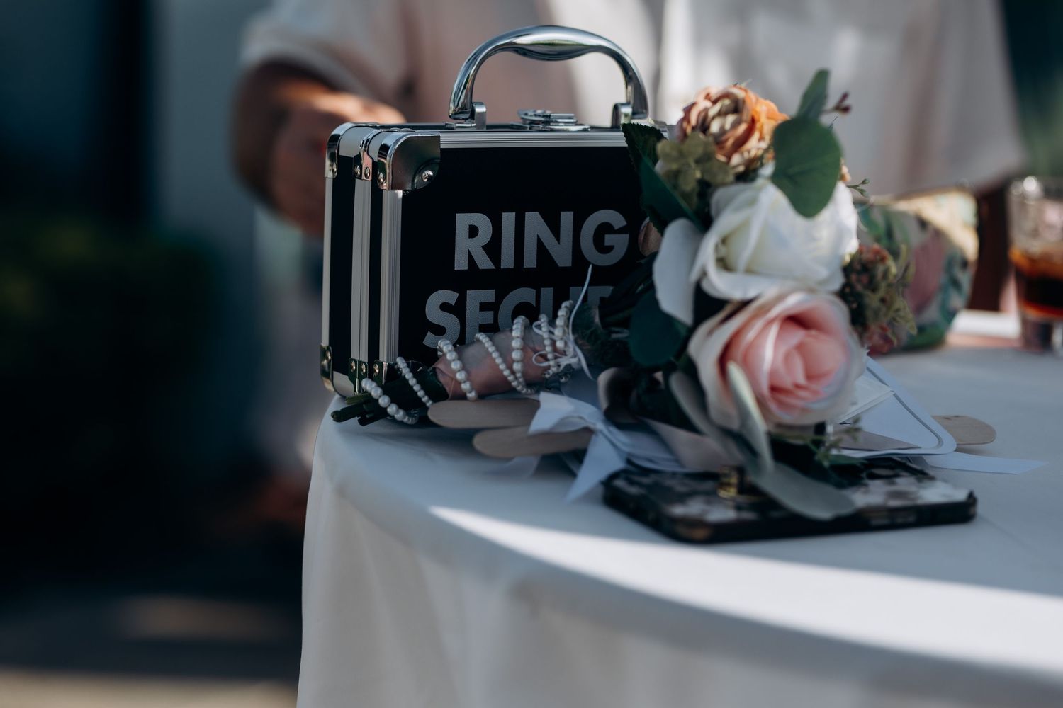 Wedding decor featuring a black Ring Security sign with floral arrangements.