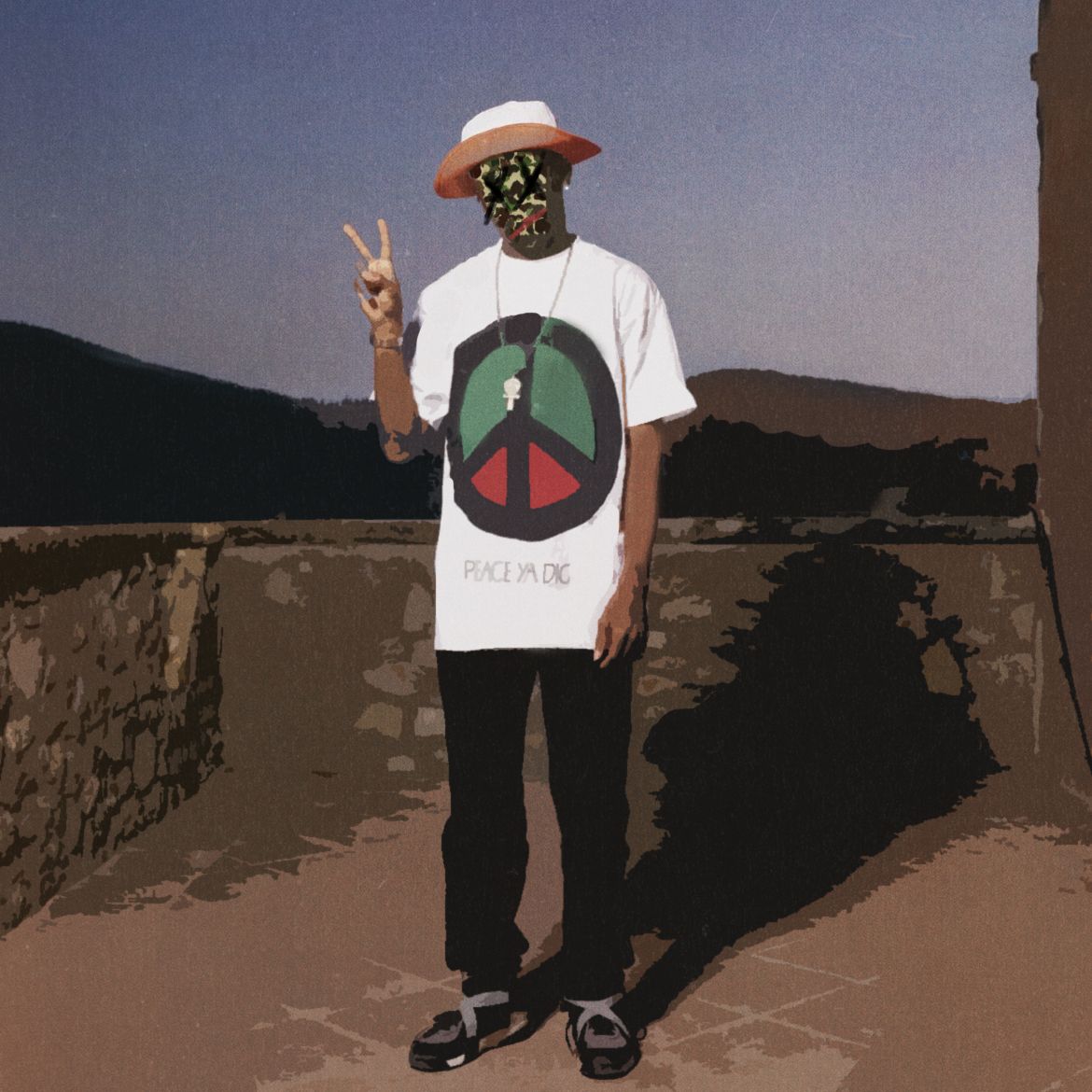 Man in white peace sign tee, black pants, floral mask and hat, making peace sign outdoors with hills in background.