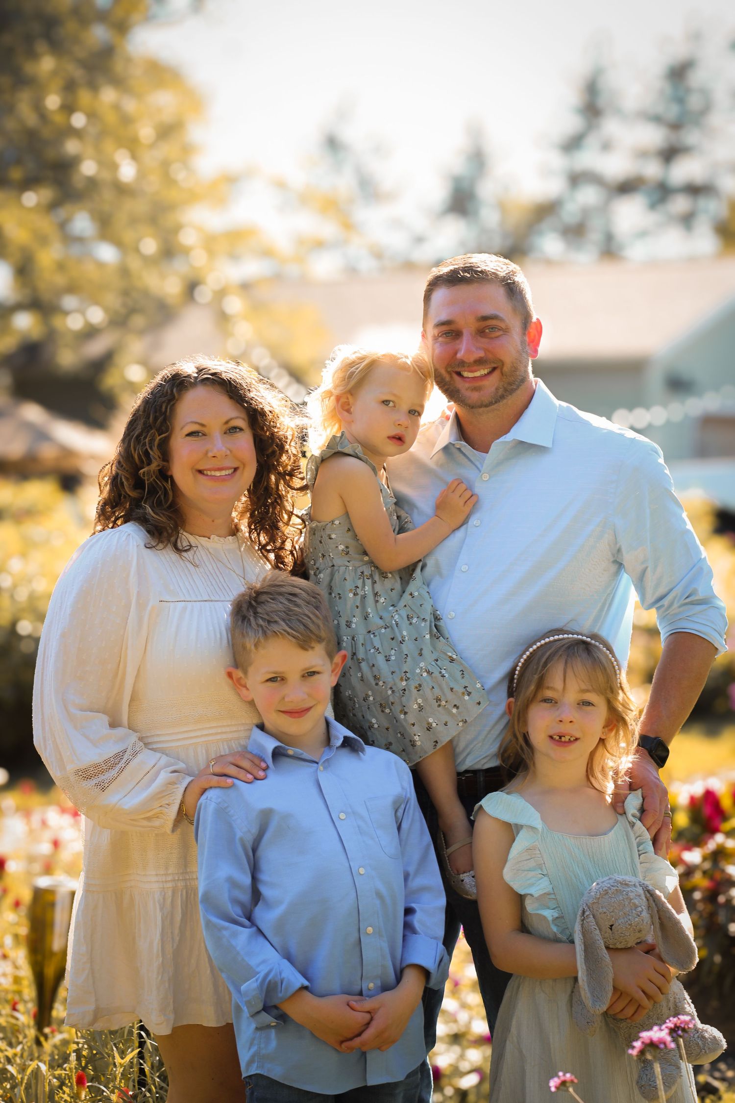 a family smiling together while standing in a flower field