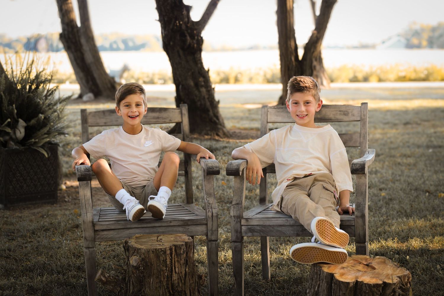 two young boys sitting in chairs and smiling