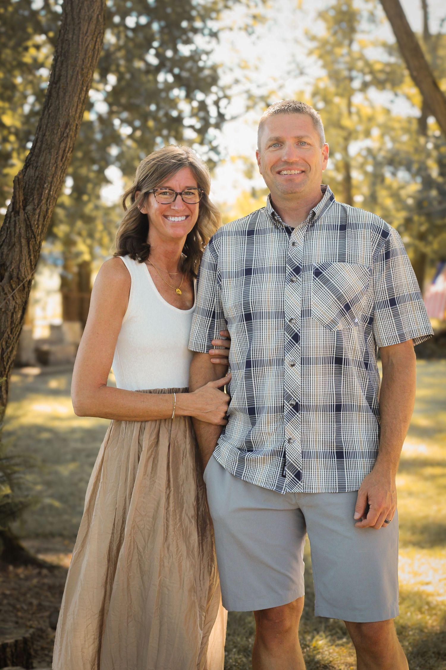 photo of couple with trees and fields in background scenery