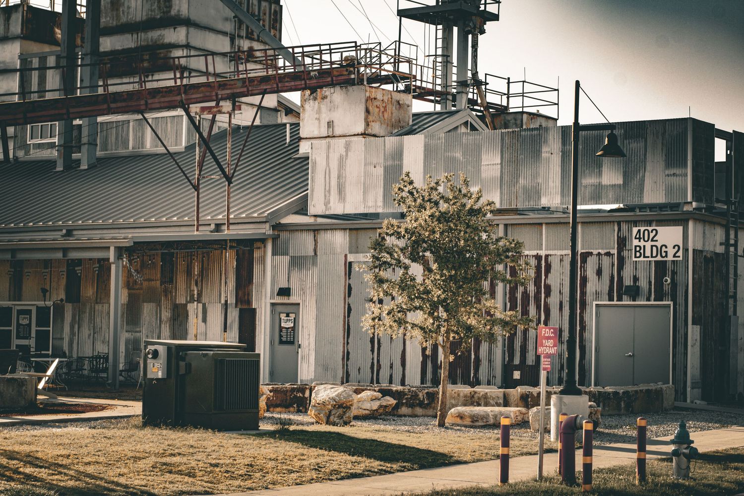 Row of abandoned or vintage industrial buildings with rustic architecture in sepia tones.