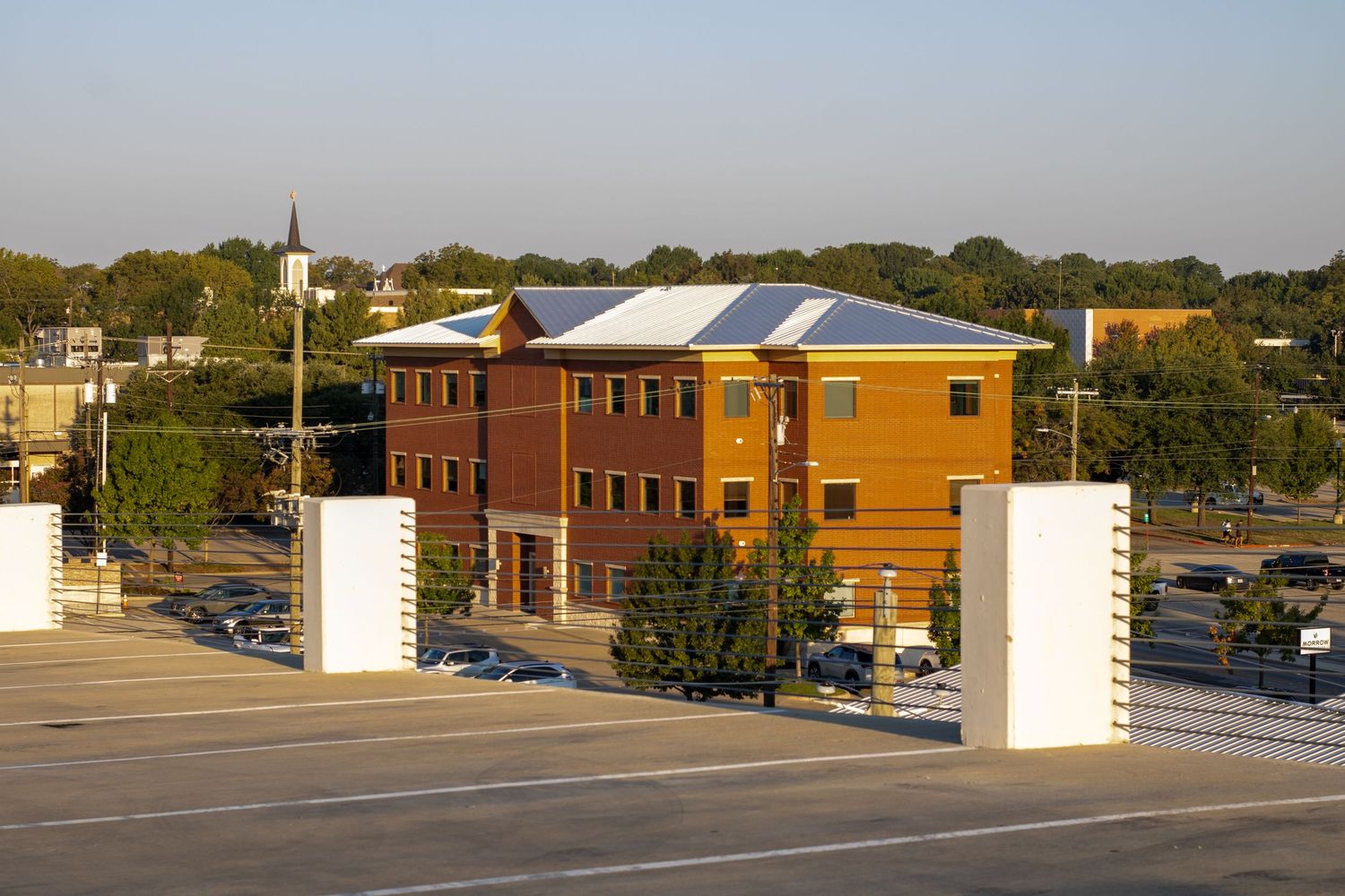 Aerial view of modern commercial buildings and parking lots in an urban setting.