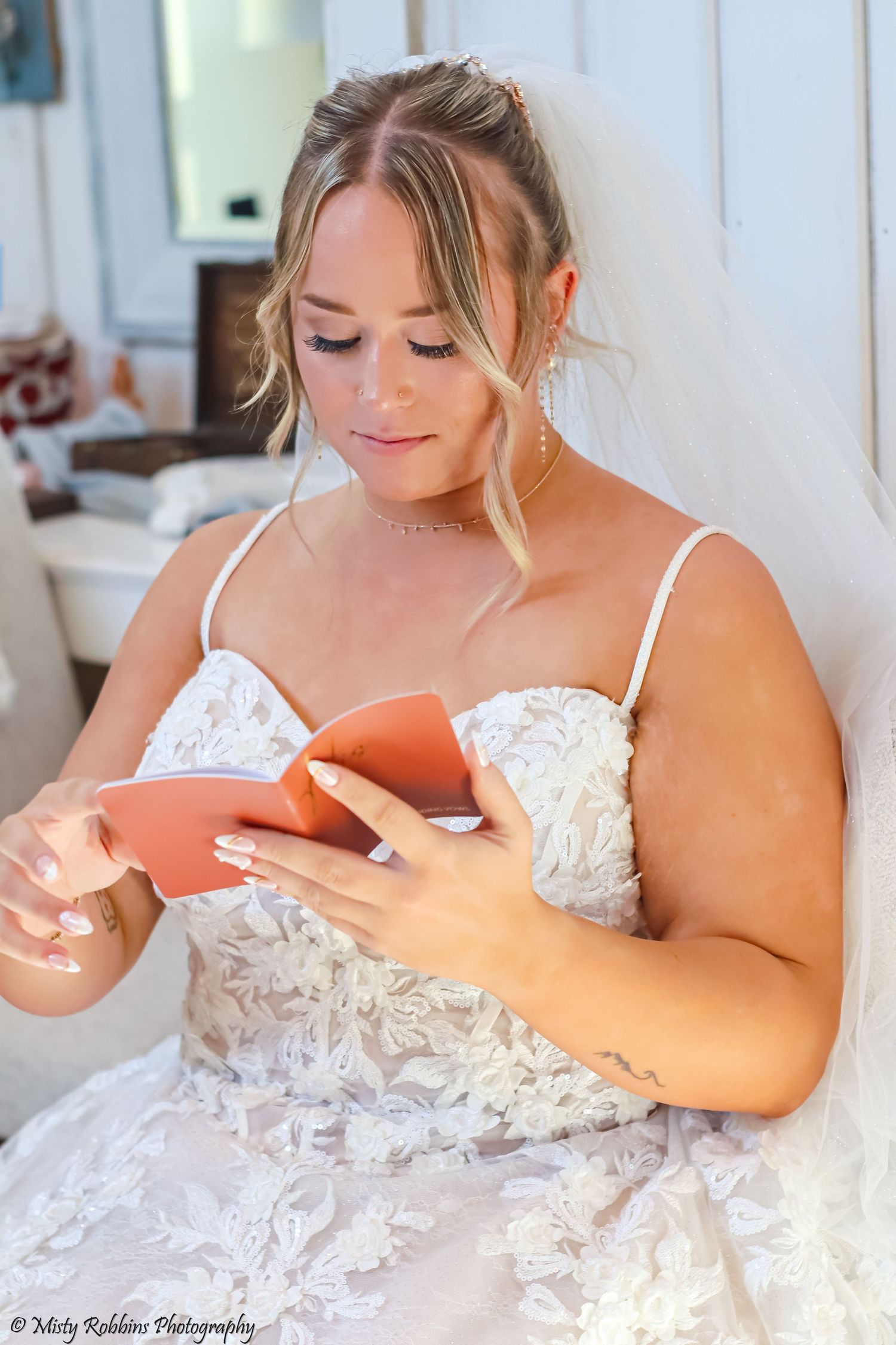 A bride in a white lace gown poses on a couch in a series of four boudoir-style photos.