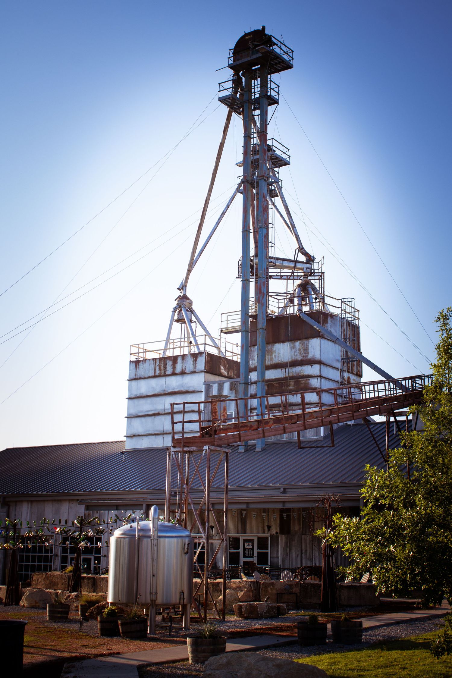 White industrial grain elevator with metal towers and equipment photographed from multiple angles.