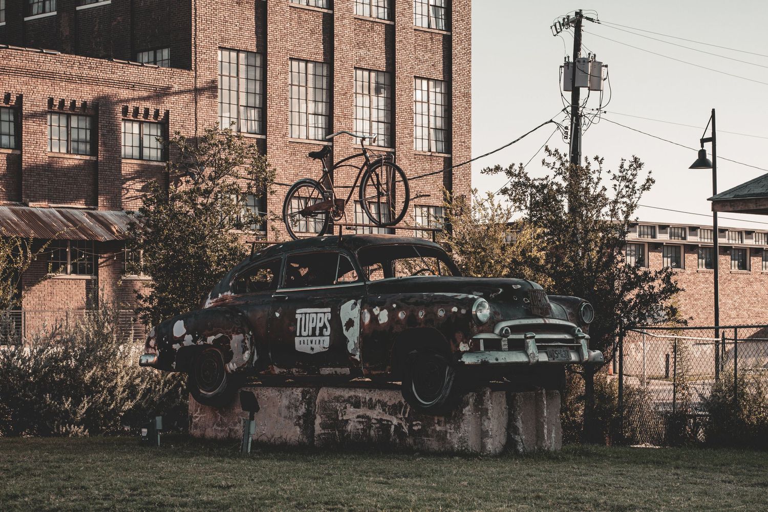 Vintage brick factory buildings with industrial architecture and power lines at dusk.