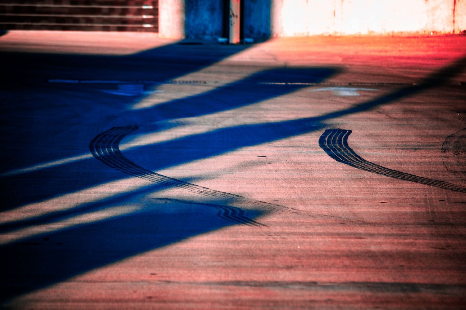 Artistic photograph of dramatic shadows cast by window blinds on a wooden surface creating abstract patterns.