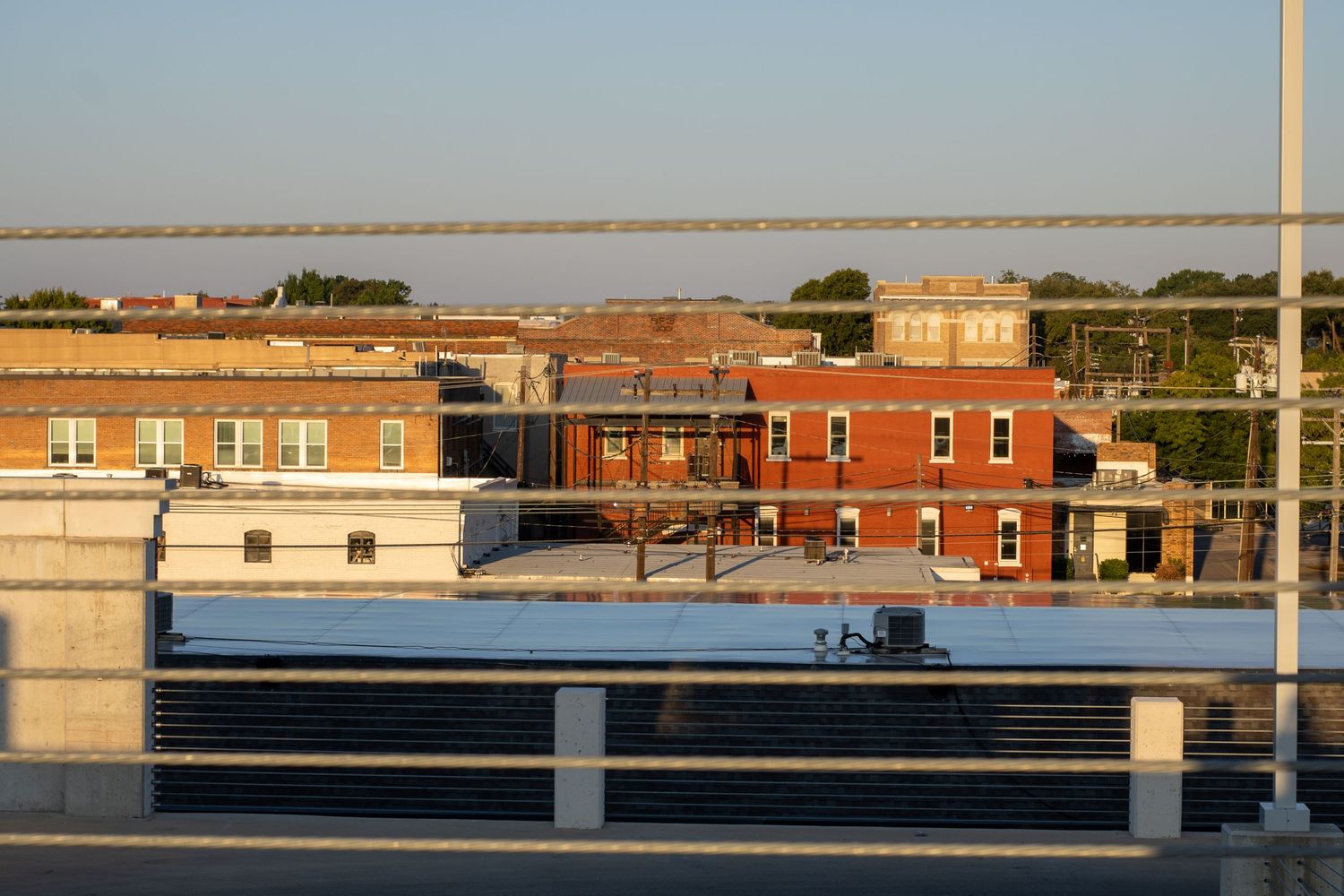 Row of historic red brick buildings with storefronts along a commercial street.