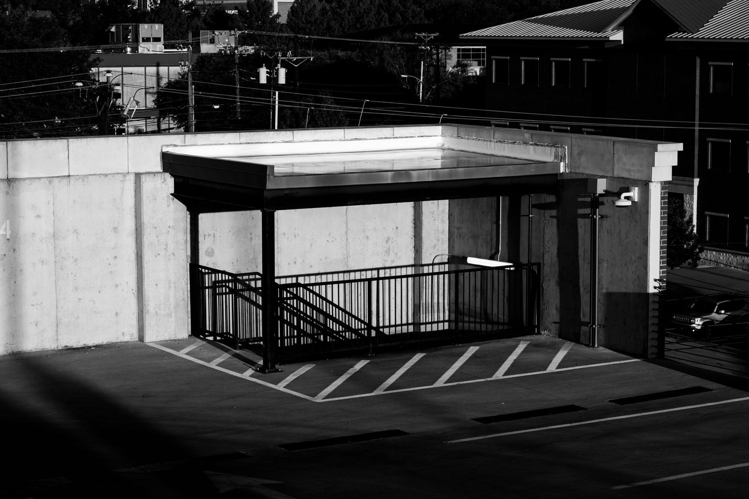 A series of black and white architectural photographs showing empty parking lots and building exteriors at night.