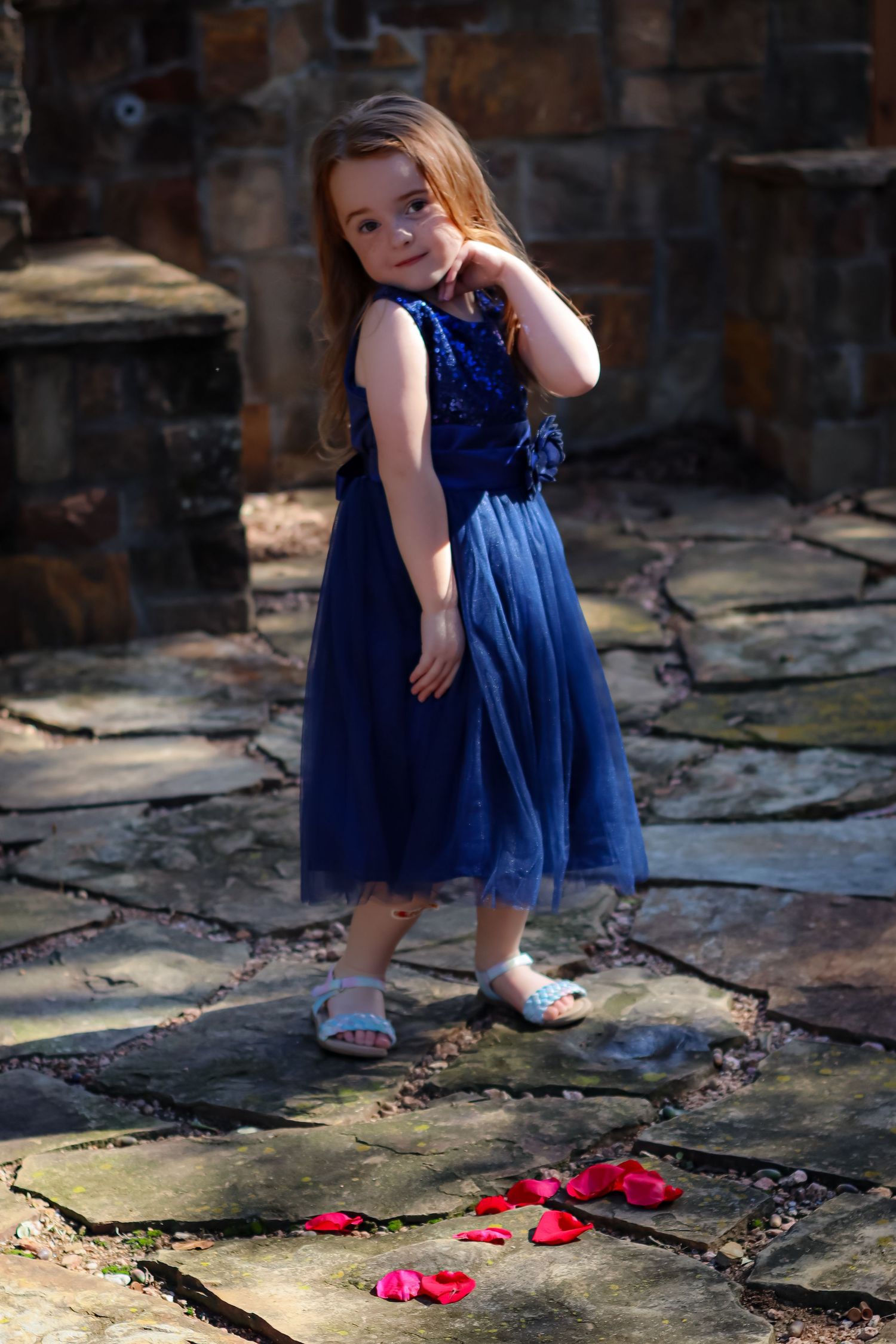 A series showing a blue dress and red shoes on stone pavement in natural lighting.
