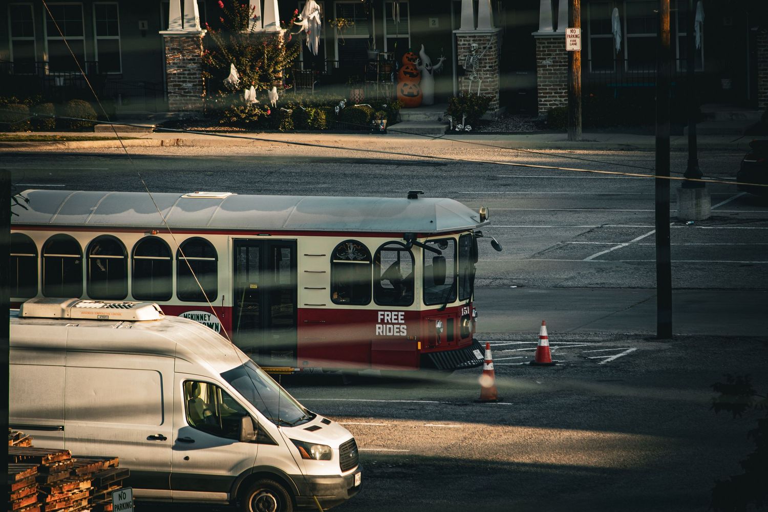 Urban street view with parked vehicles and buildings in the late afternoon light.