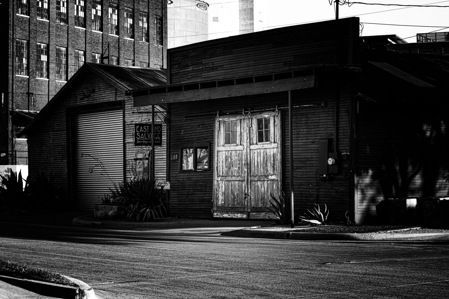 Black and white photo of a loading dock at a warehouse with multiple bay doors and ramps.