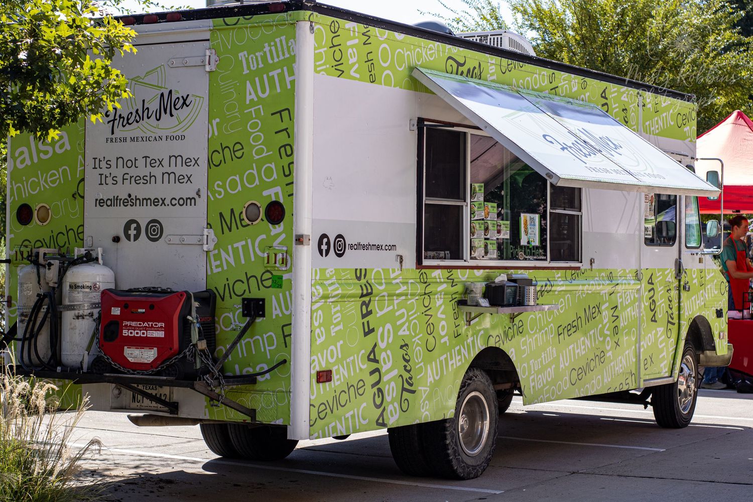 A lime green food truck with white text and service windows parked outdoors.