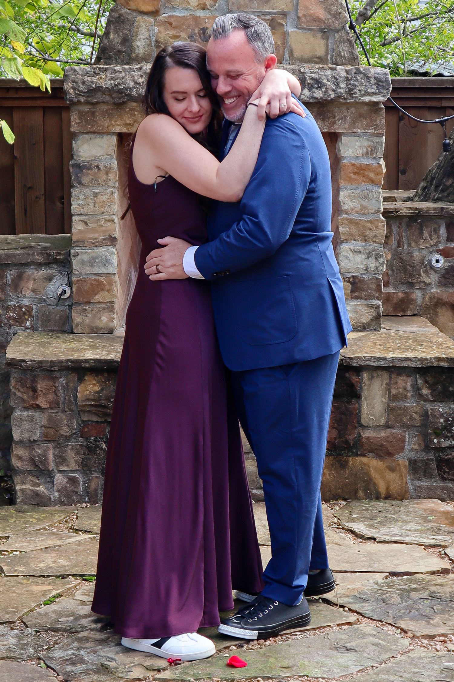 Couple in formal wear share an intimate moment on stone steps during photo session.