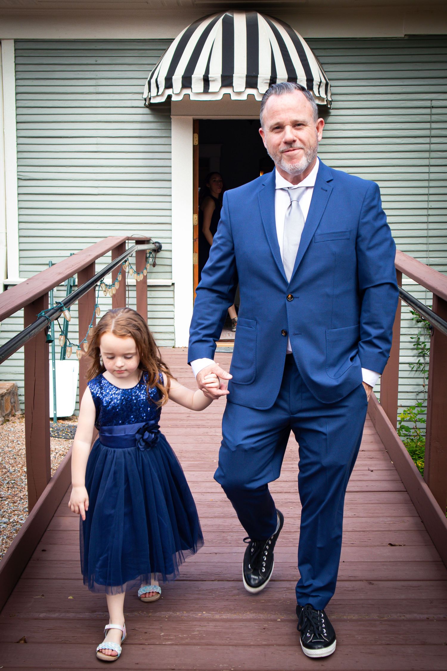 A series of photos showing coordinated navy blue outfits on a wooden deck with striped awning in background.