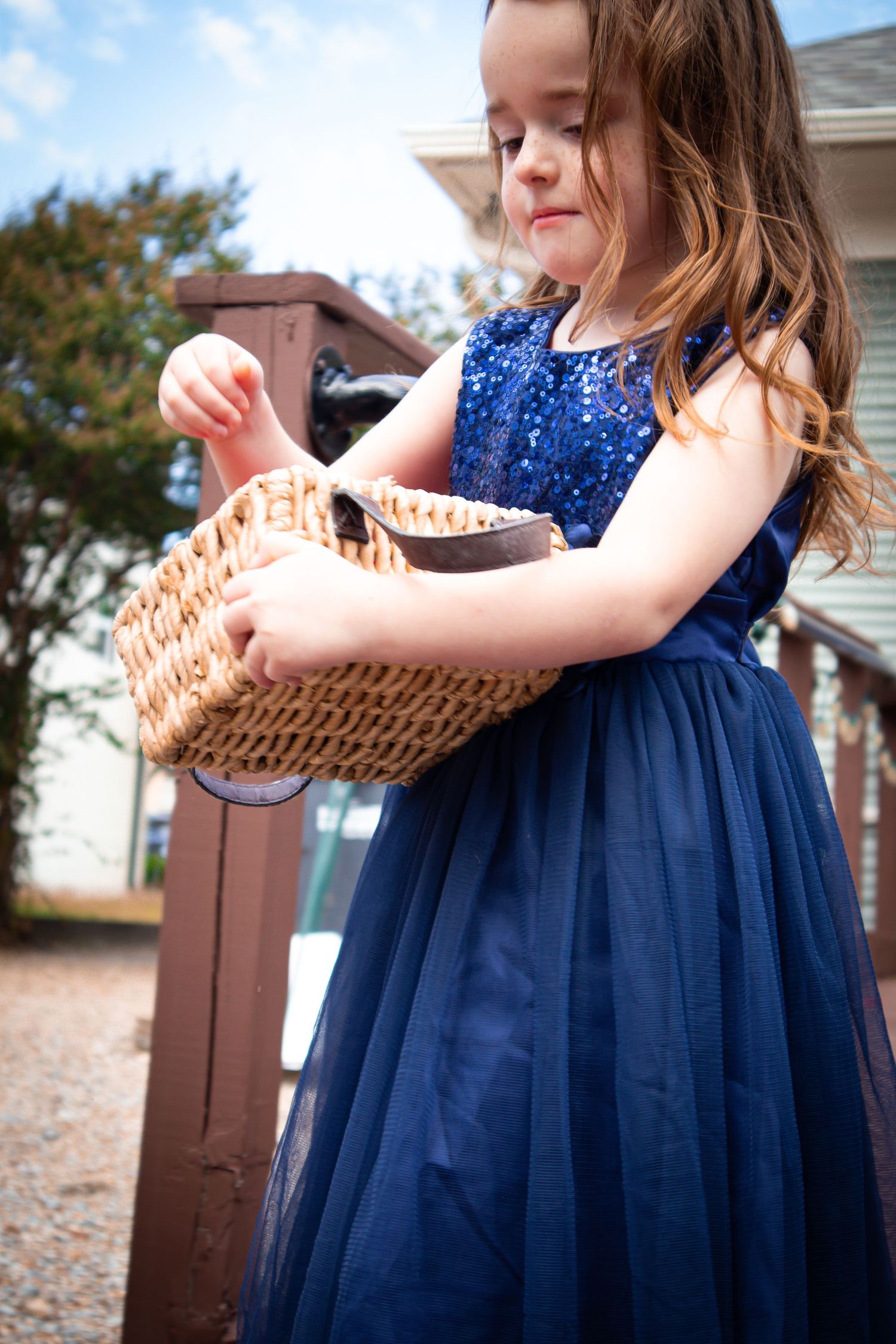 A sequence of shots showing a navy blue dress and woven basket against an outdoor background.