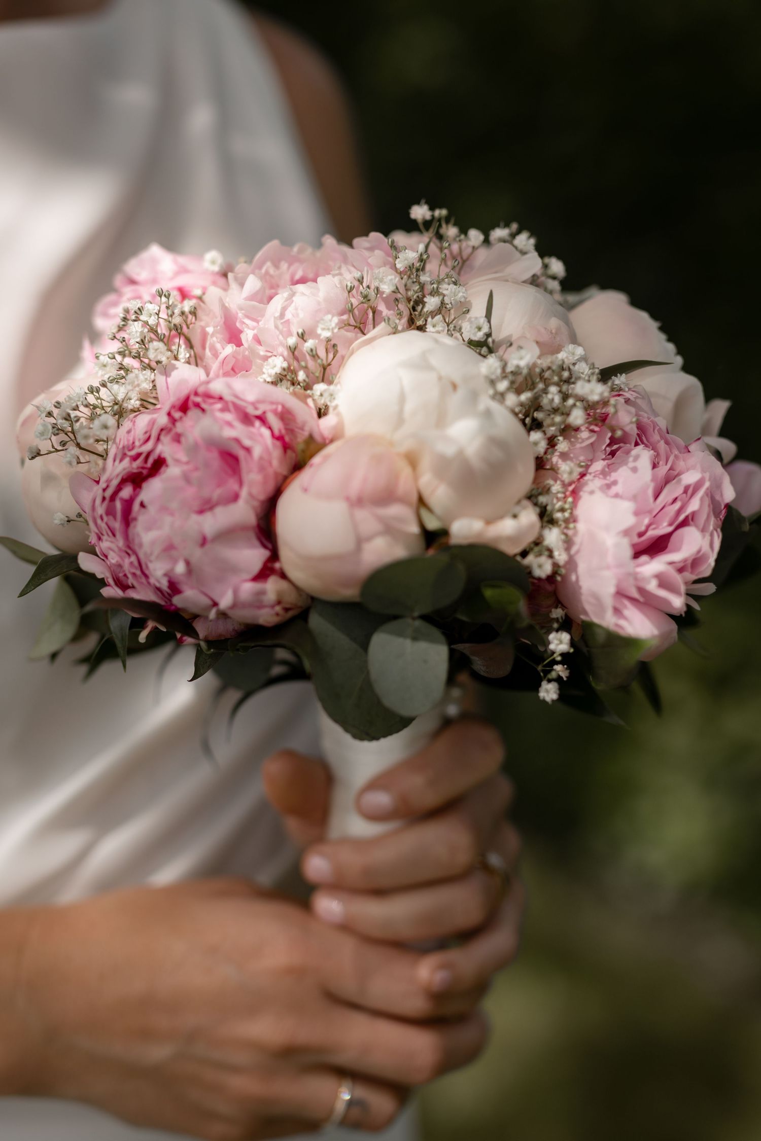 A stunning bridal bouquet with pink peonies, white roses, and delicate baby's breath.