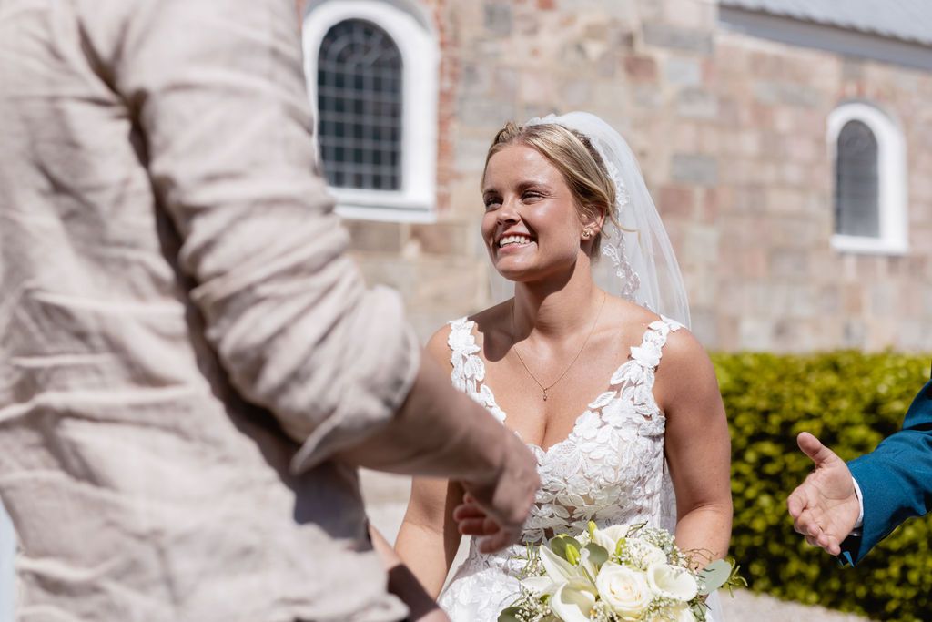 A joyful moment captured during an outdoor wedding near a stone church building.