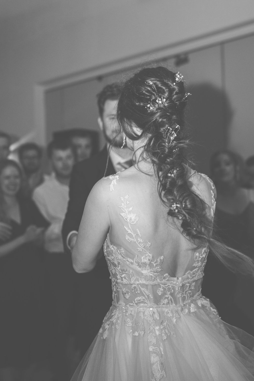 Wedding reception dance floor moments captured in atmospheric black and white photography.