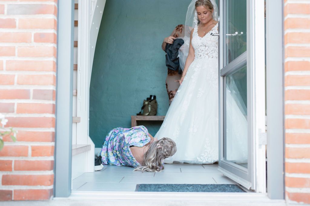 Wedding dress detail through window frame with brick exterior.