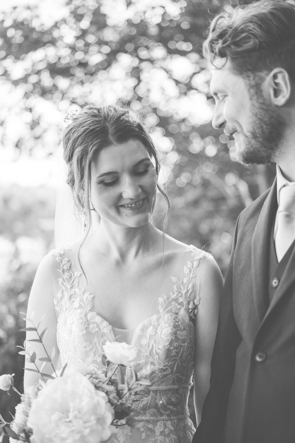 Black and white romantic wedding portrait captured in soft natural lighting.