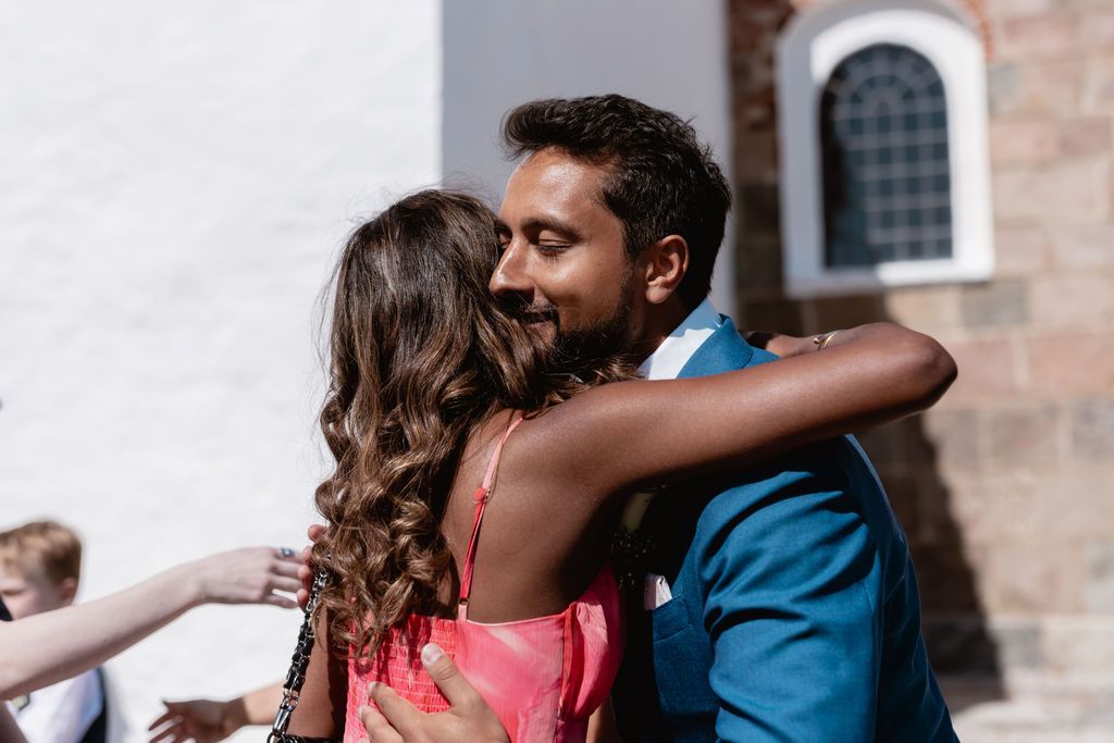 Emotional embrace during outdoor wedding celebration.