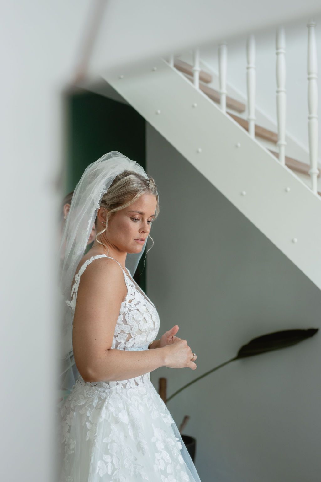 Elegant bridal portrait under a staircase with soft lighting.
