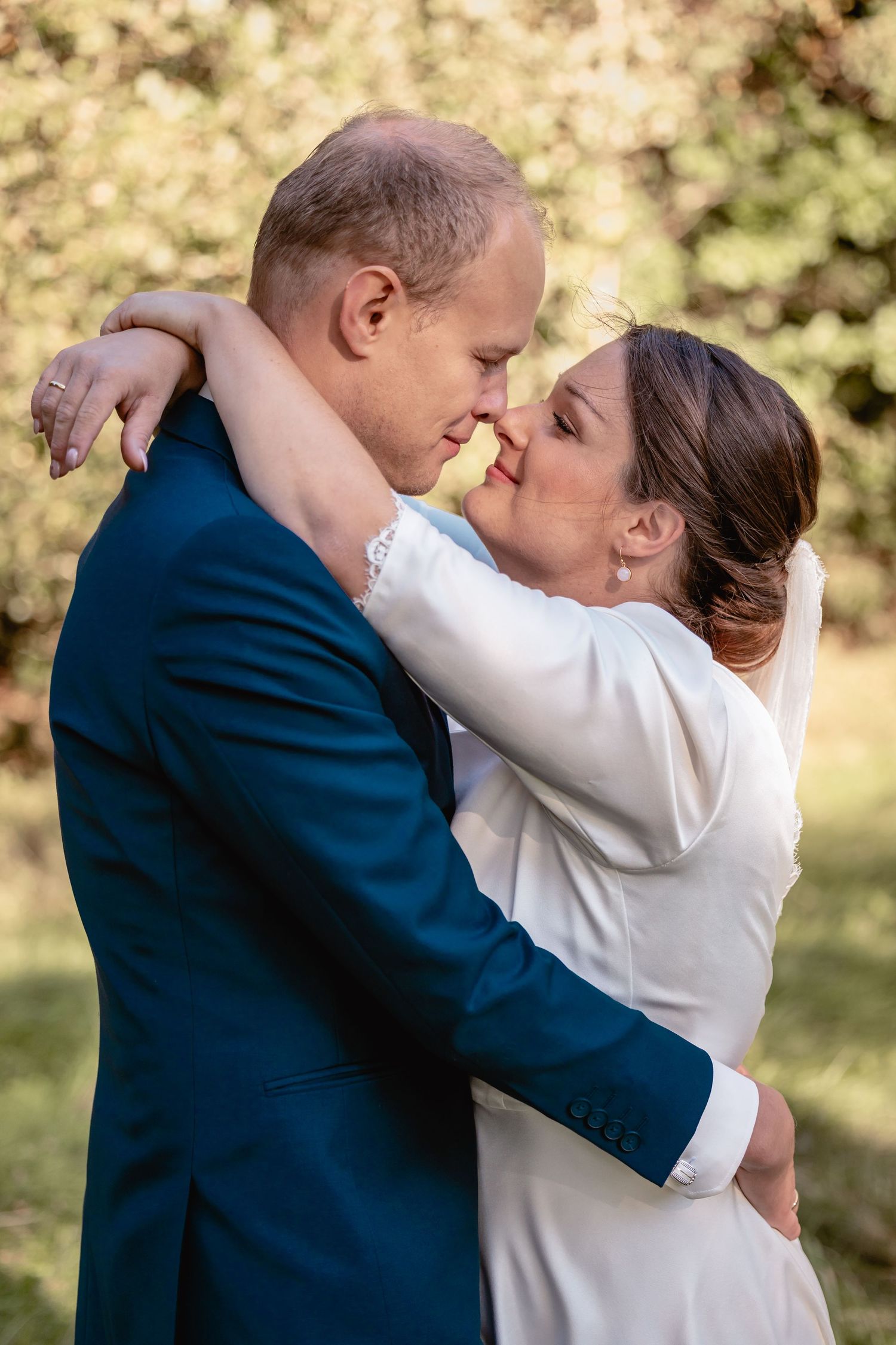 Romantic wedding portraits showing intimate embraces between newlyweds outdoors.