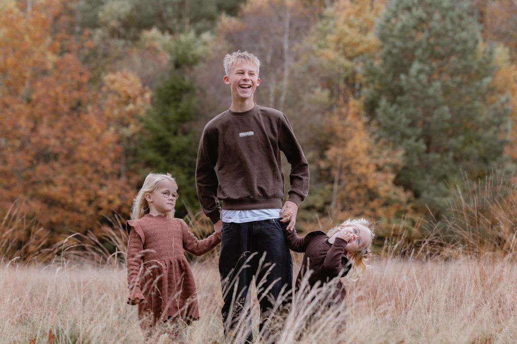 Natural family interactions photographed in a golden autumn field.