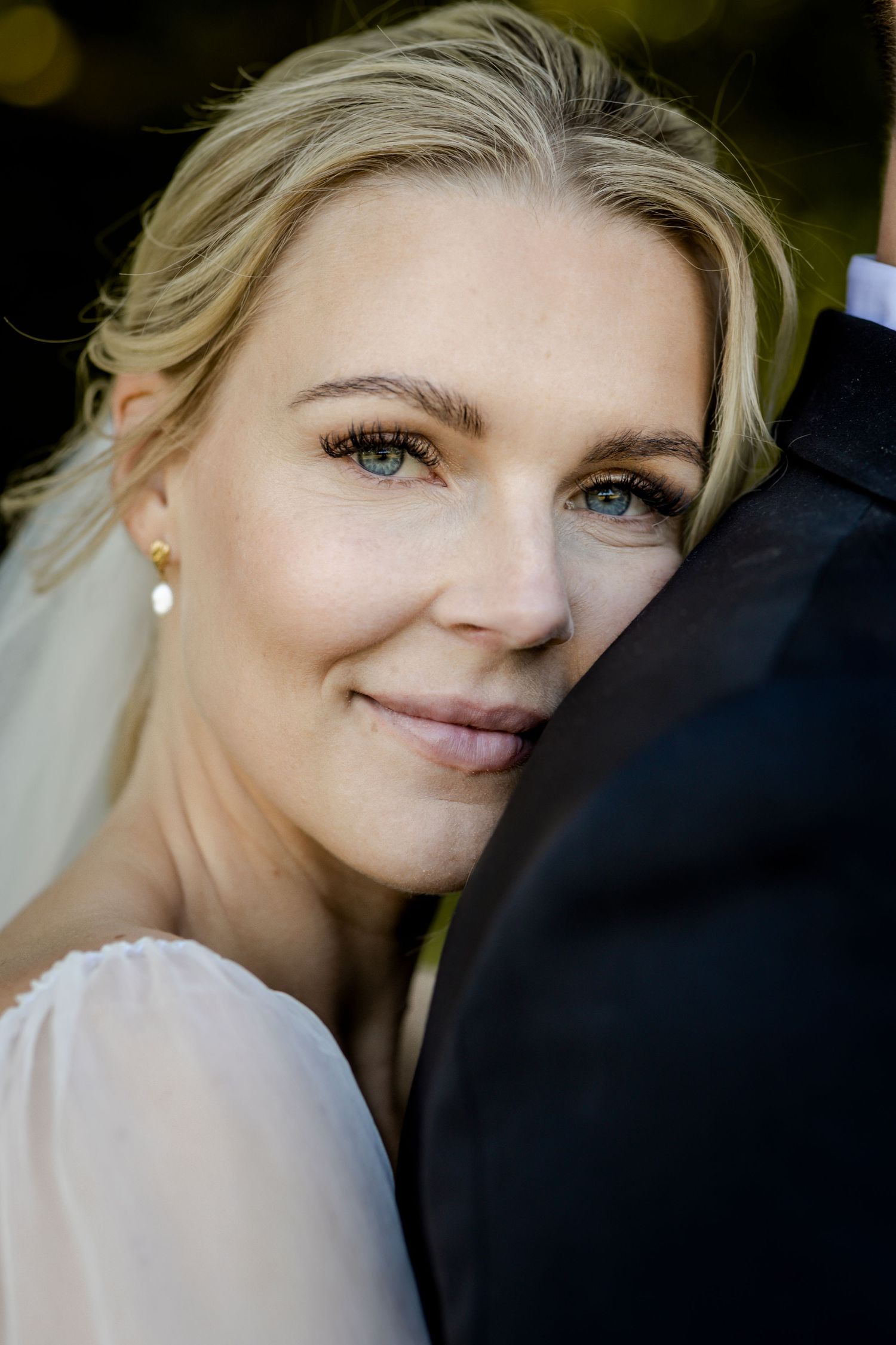 Soft romantic portrait in natural light with elegant bridal makeup.