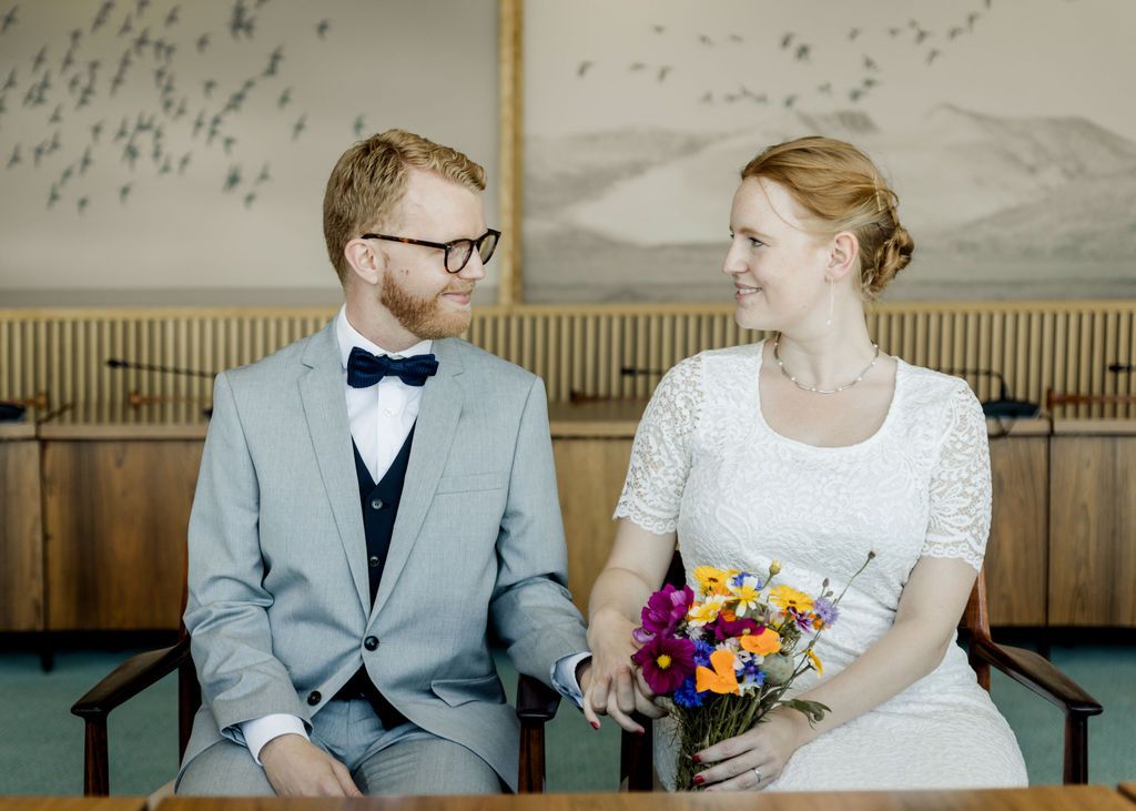 Brudepar står sammen med brudebuket, roligt og ægte øjeblik