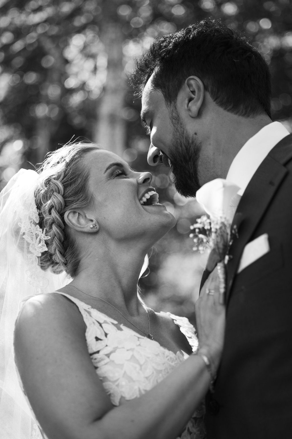 Black and white portrait of newlyweds sharing a laugh during their wedding photoshoot.