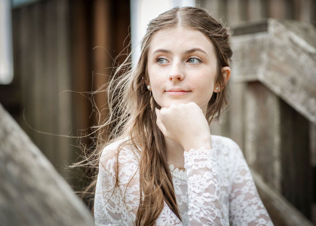 Romantic bridal portraits showing intricate lace details against natural backdrop.