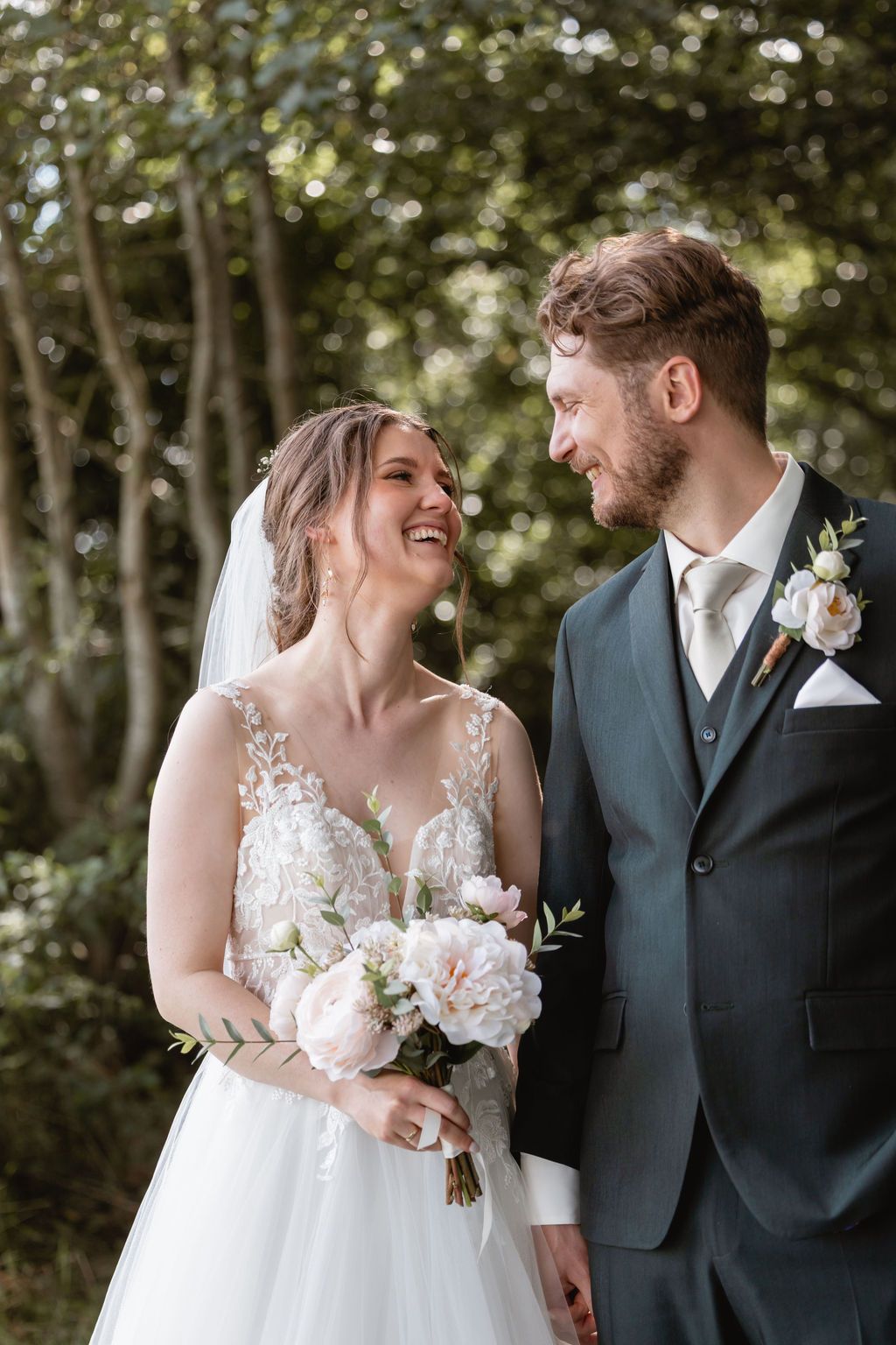 Happy couple shares candid moment during outdoor wedding photoshoot.