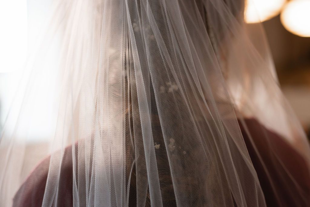Close-up shot of flowing white wedding veil fabric with soft lighting.