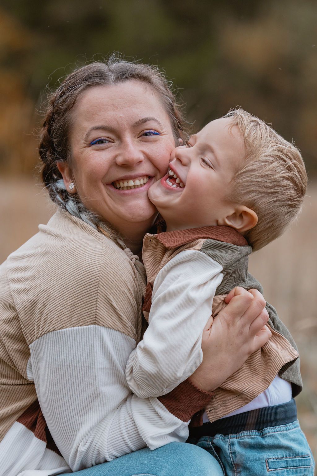 A joyful moment of laughter and embrace captured in warm autumn lighting outdoors.