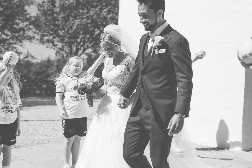 Black and white outdoor wedding photo with joyful celebration.