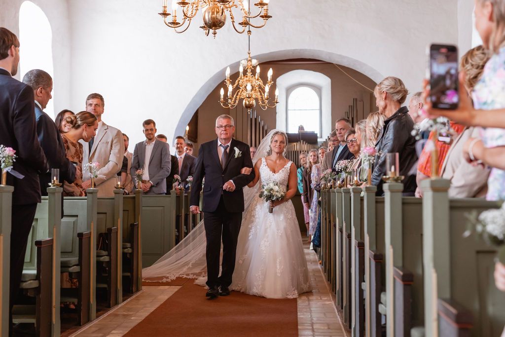 Wedding ceremony in a beautiful historic church with arched ceilings and chandeliers.