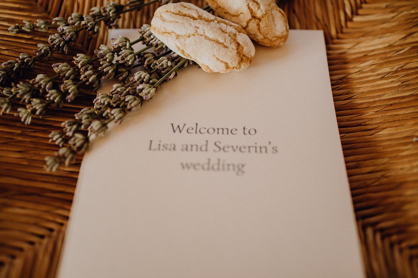 Wedding program card reading Welcome to Lisa and Severin's wedding decorated with lavender and cookies. Tuscany Villa Catignano