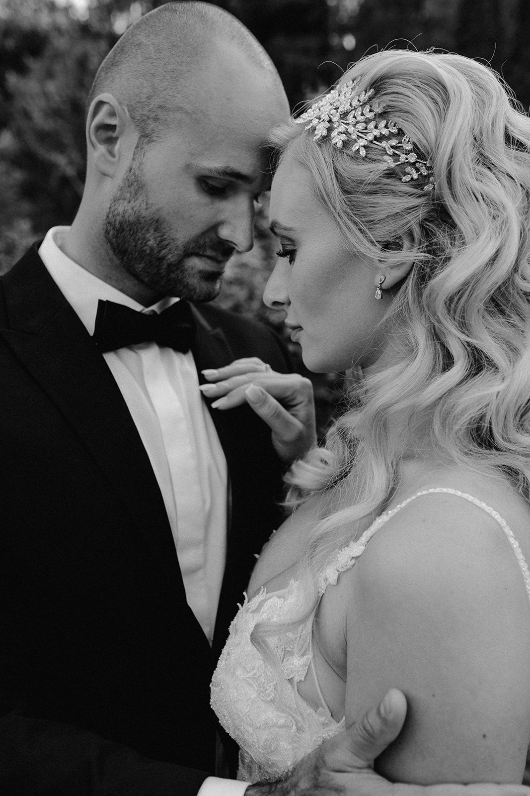 Bride and groom share an intimate close moment, black and white portrait with crystal hair piece.