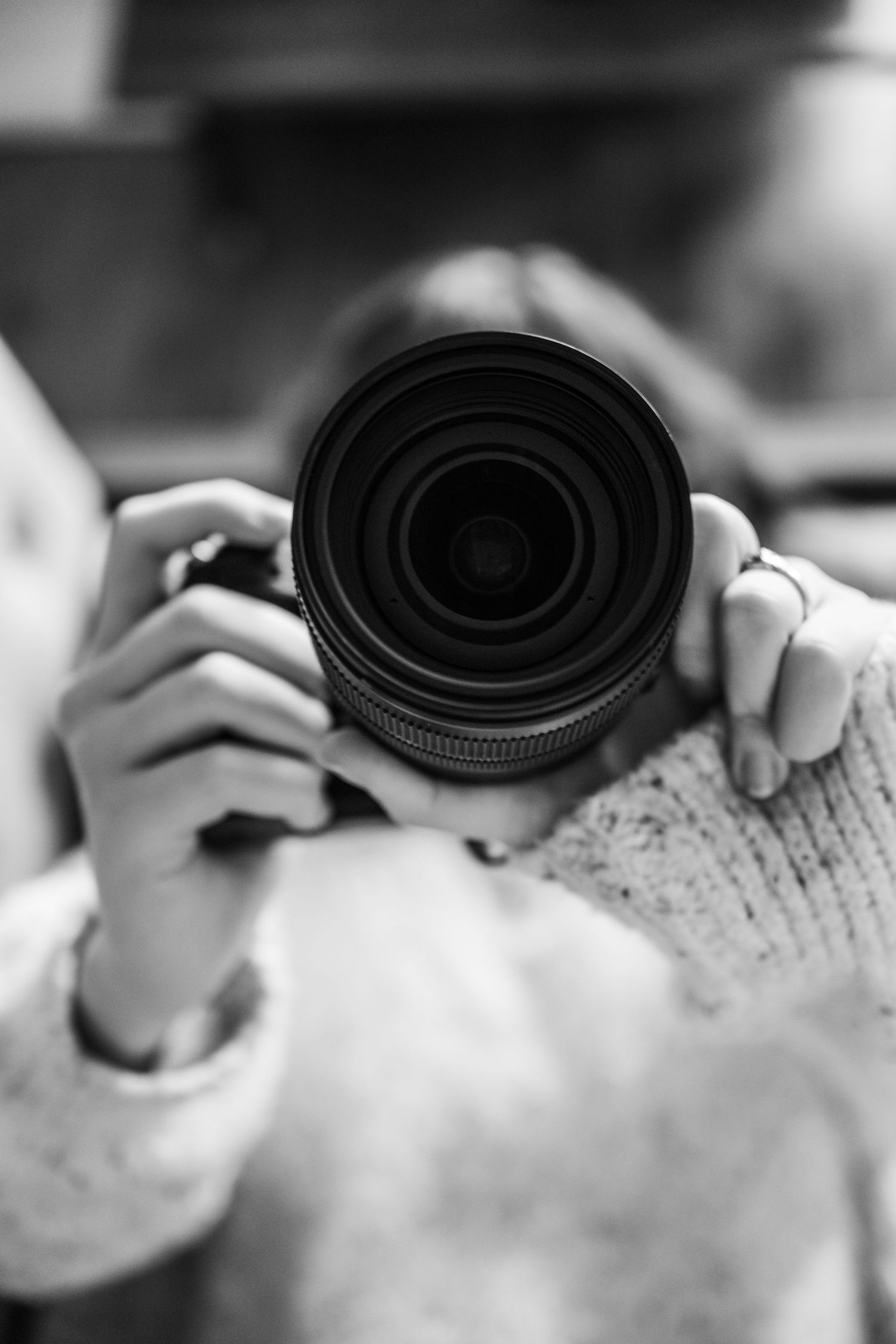 Black and white macro shot of camera lens being adjusted on textured surface.