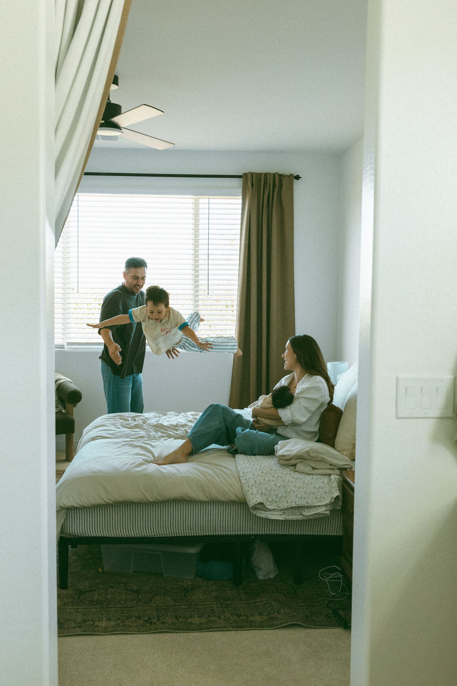 family playing on the bed during a newborn session