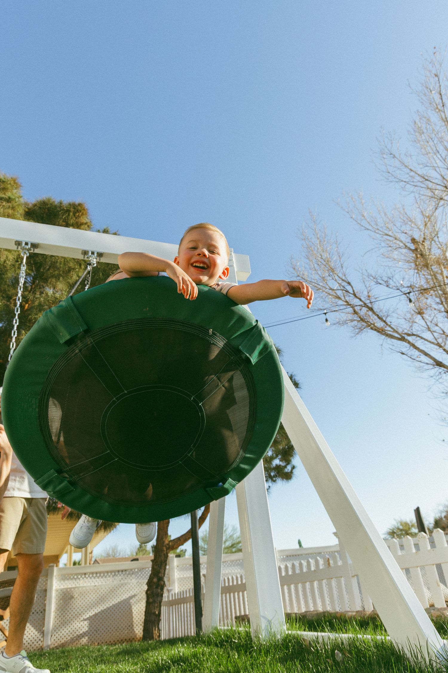 young boy playing on the swingset