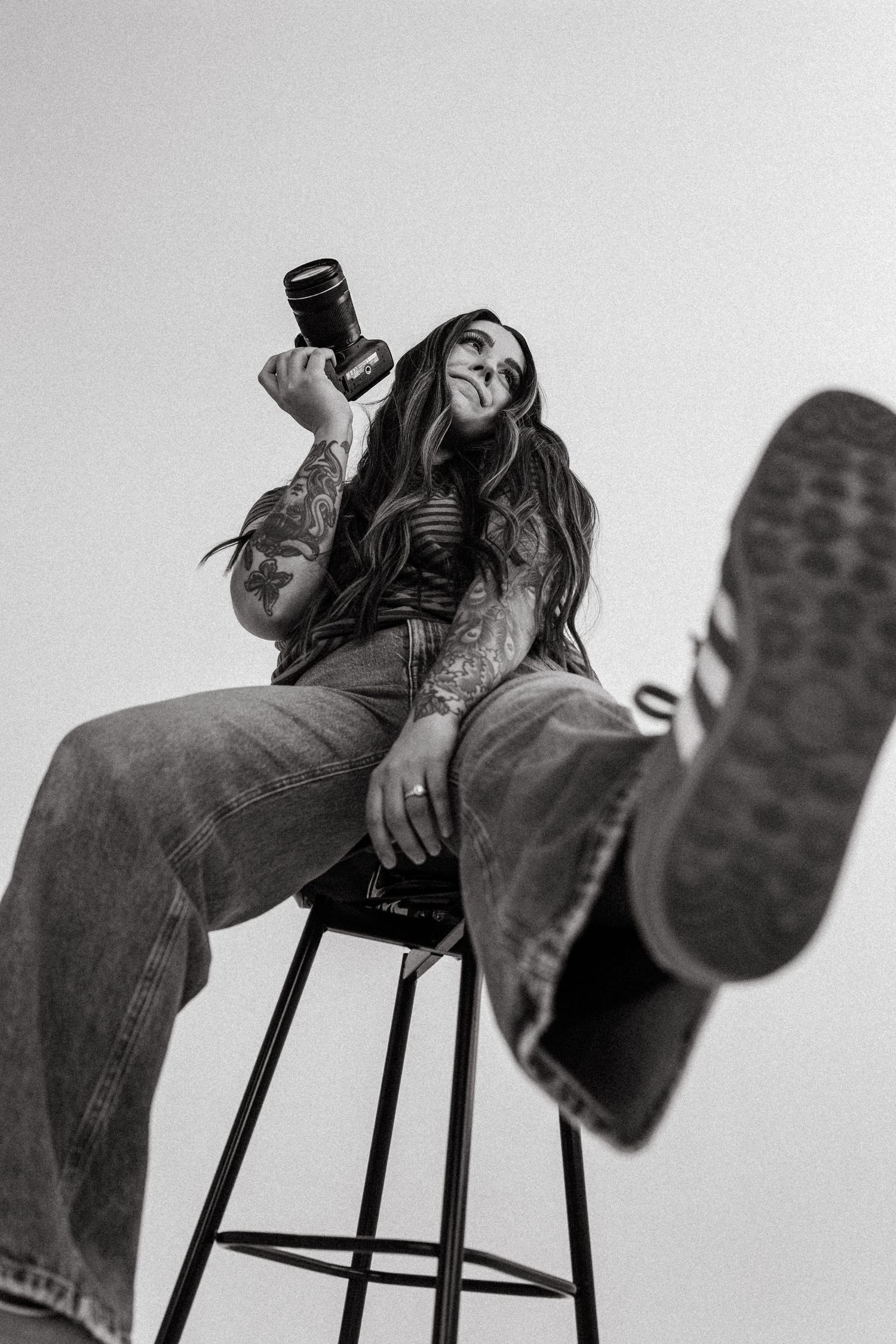girl kicking her foot out as she sits on a stool