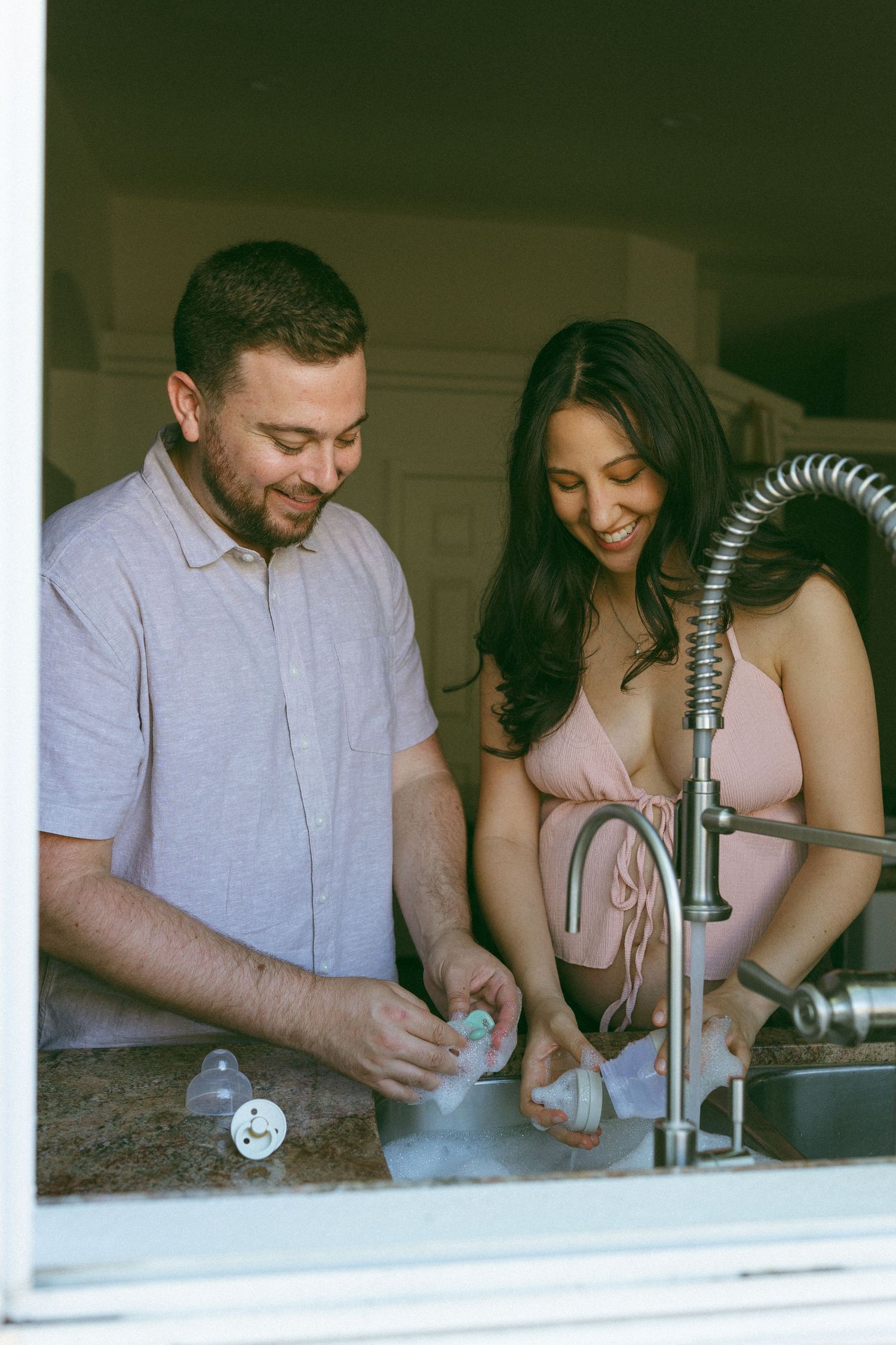 pregnant couple washing bottles