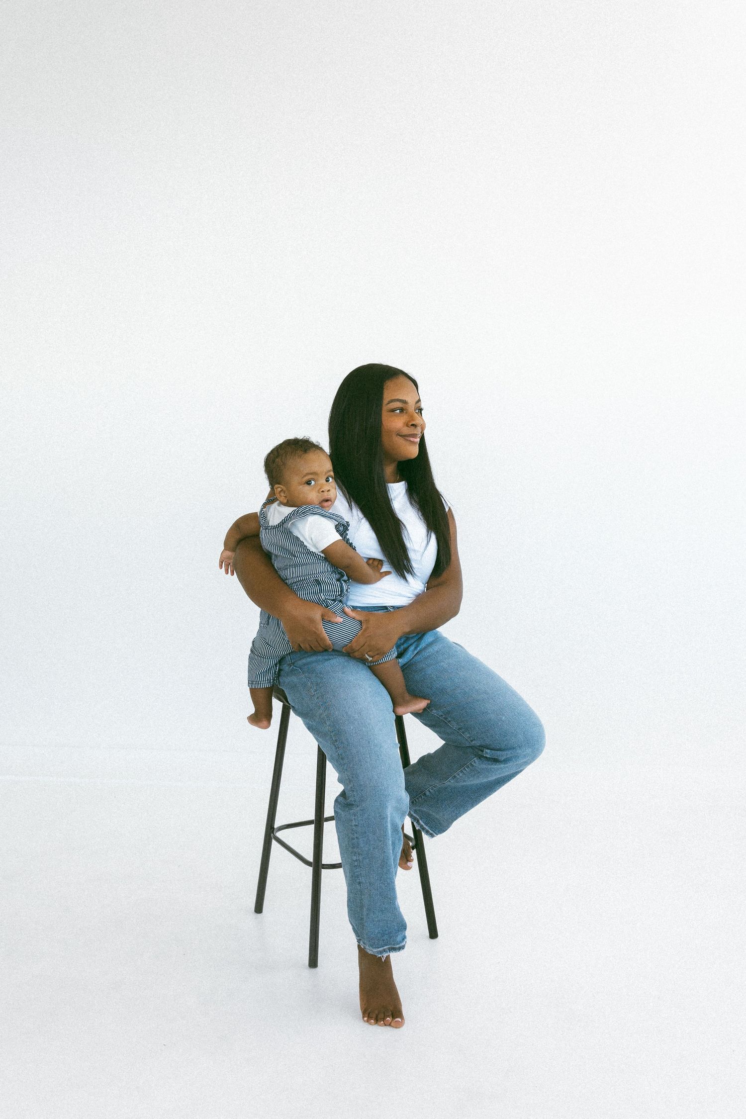 woman holding young son while sitting on a stool