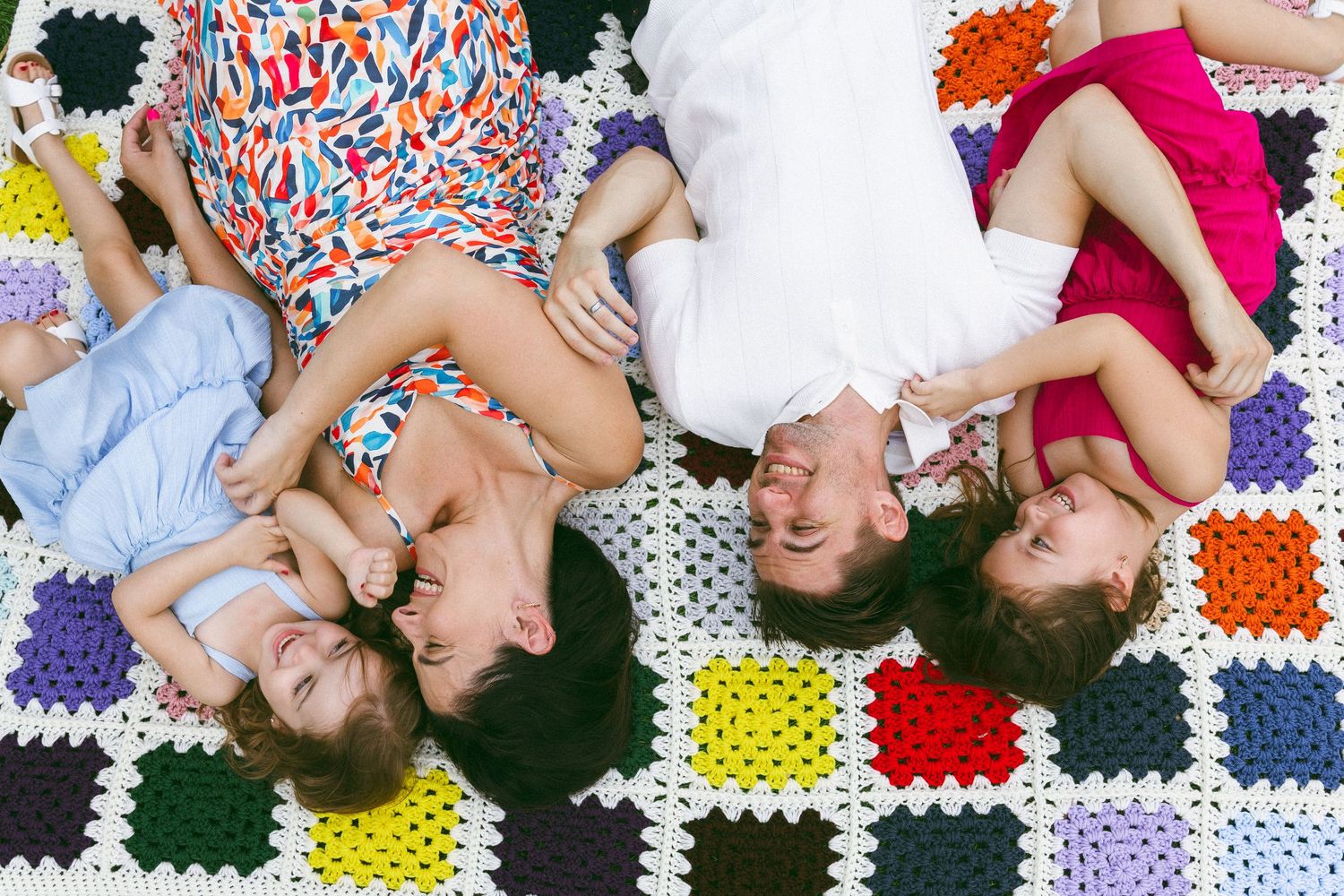 family laying on a colorful blanket during a lifestyle session