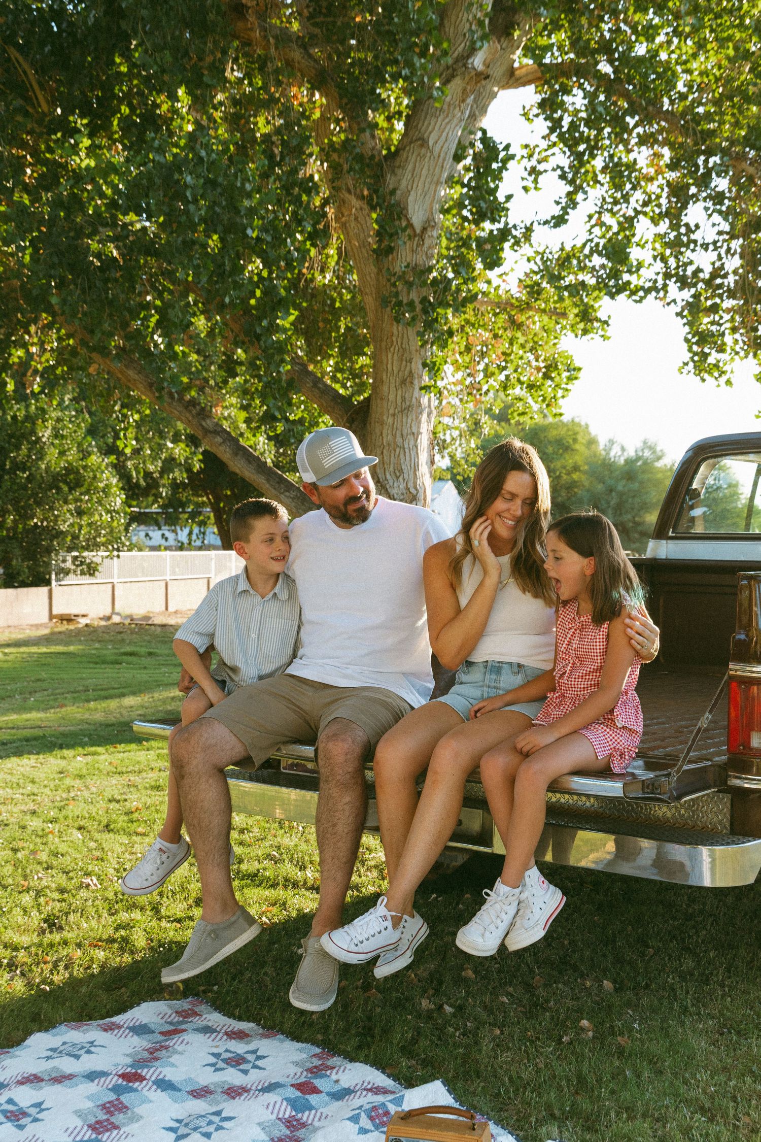 family sitting on the bed of a truck during a backyard session