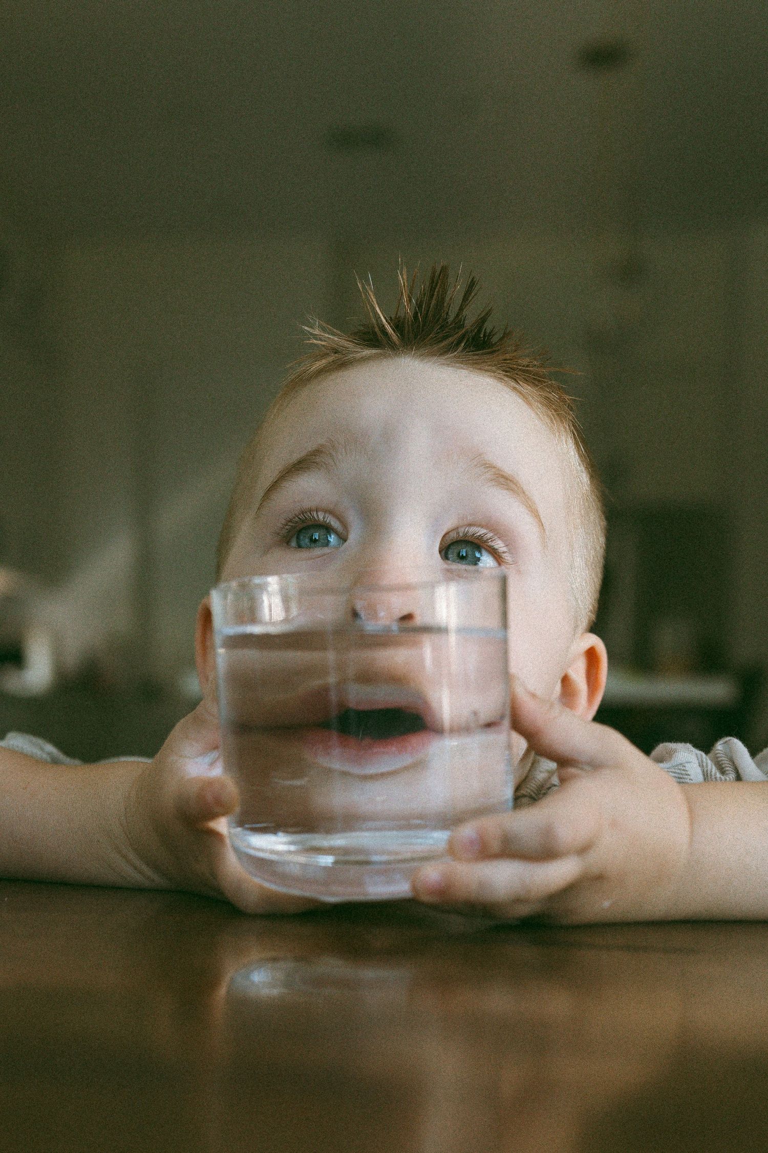 child being playful with a drinking glass during a lifestyle session